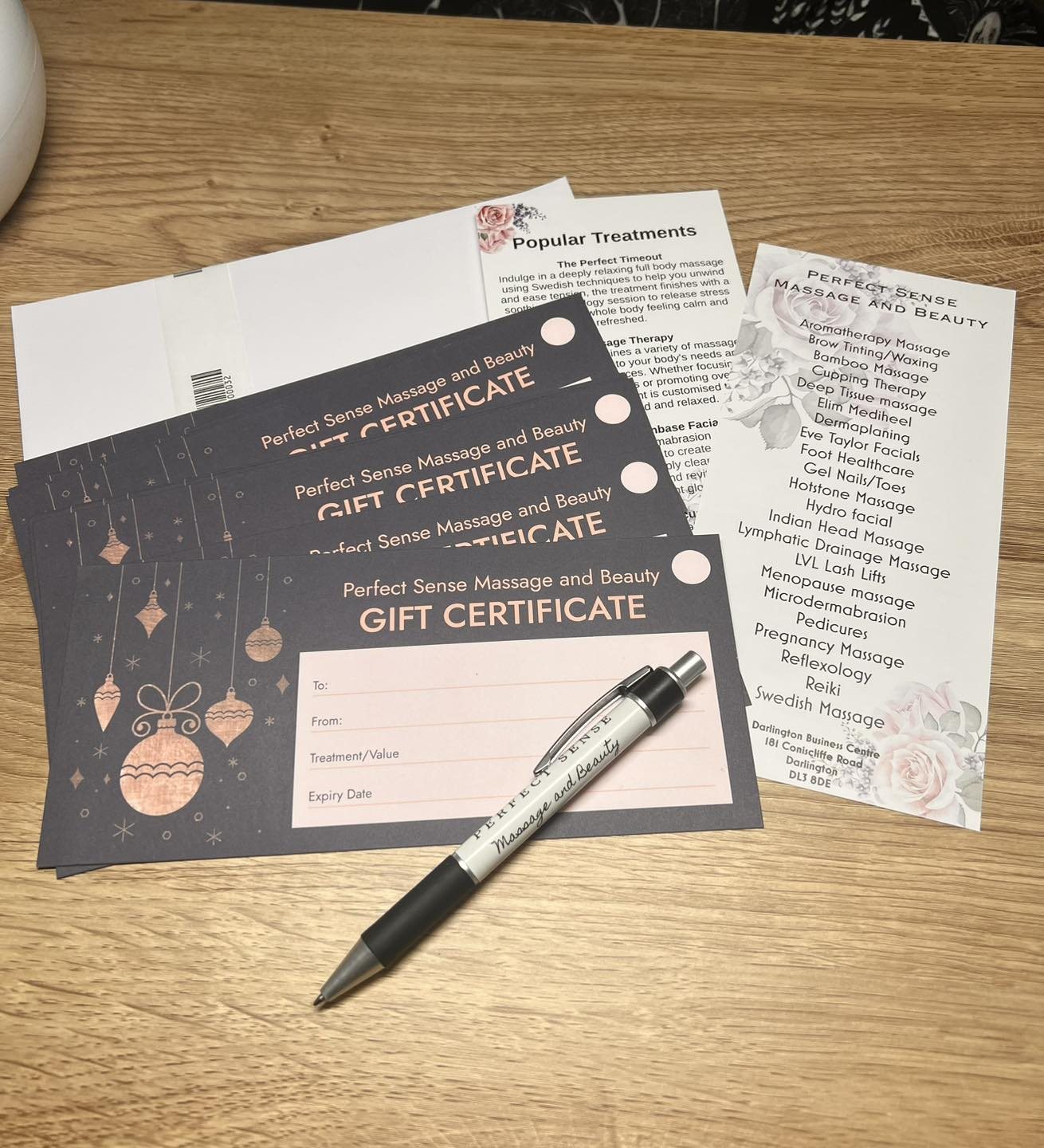 Perfect Sense gift certificates and treatment lists on a desk