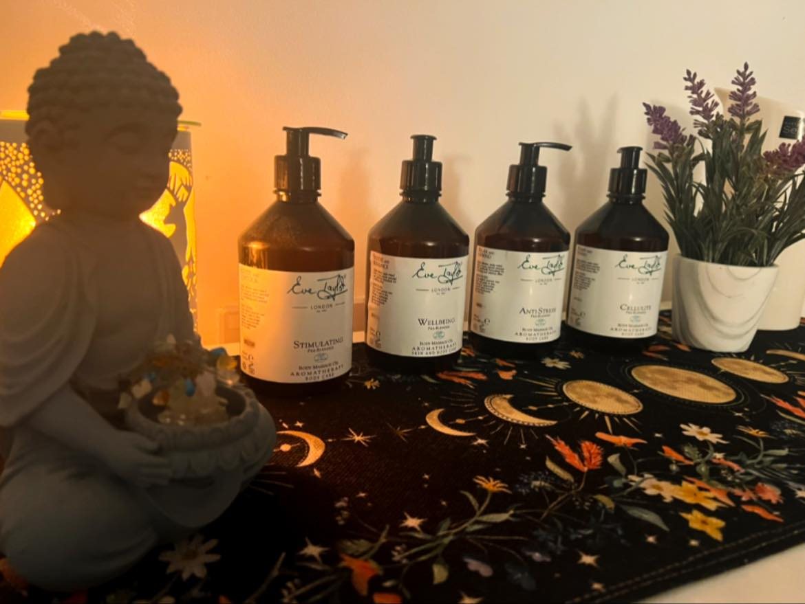 Eve Taylor massage oils beside a candle holder and lavender
